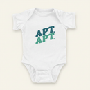 APT. APT. Onesie flat lay on clean warm ivory background, zero shadows — CULTR editorial product photo