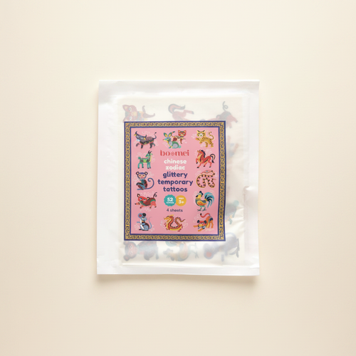 Chinese Zodiac Glittery Temporary Tattoos on clean warm ivory background, zero shadows — Bo & Mei editorial product photo