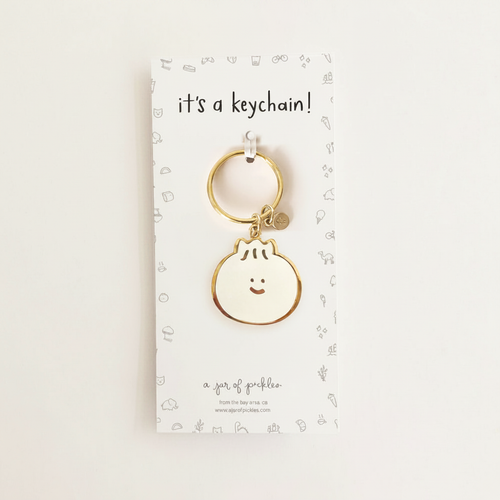 Bao Dumpling Enamel Keychain on warm ivory background
