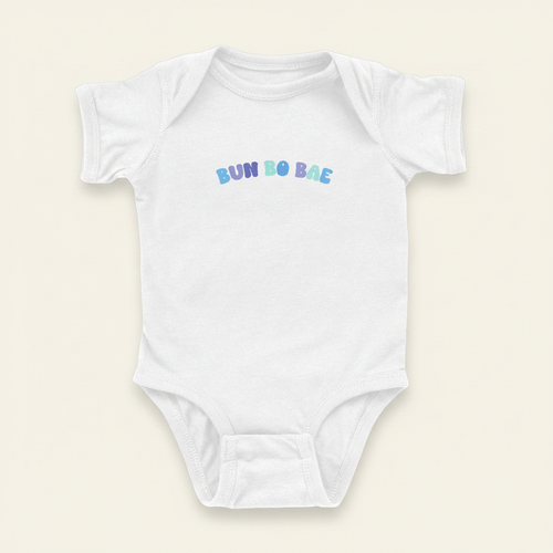 Bun Bo Bae Onesie flat lay on clean warm ivory background, zero shadows — CULTR editorial product photo