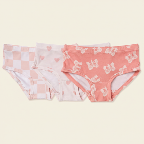 Girls Underwear 3-Pack flat lay on clean warm ivory background, zero shadows — CULTR editorial product photo