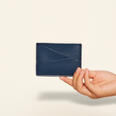 Gala Puzzle Cardholder Navy model with natural shadow on warm ivory background